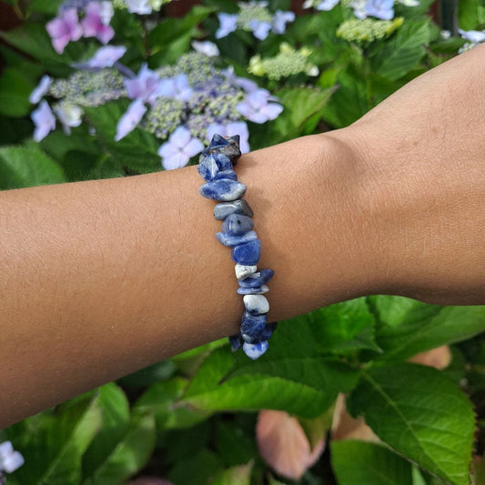 Dumi's Crystals | Sodalite Chip Bracelet (7 Inch) | Showcasing the captivating beauty of sodalite chips on a wrist. This bracelet promotes clear communication, self-expression, inner wisdom, and mental clarity. Sodalite, the stone of truth and communication, is known for its deep blue hues.