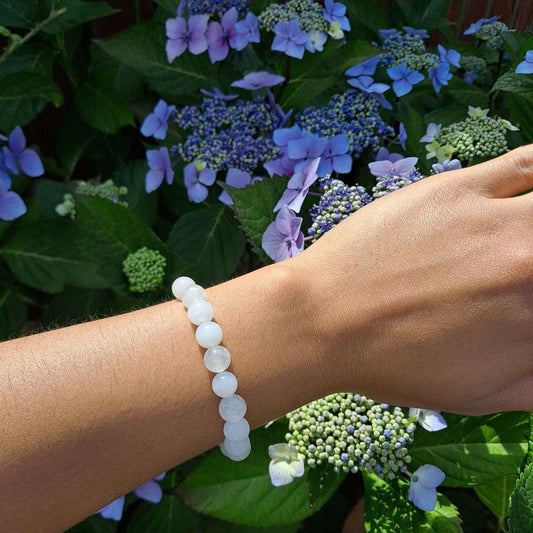 Dumi's Crystals | White Jade Stretch Bracelet (7 Inch with 8mm Beads) | Showcasing the captivating beauty of 8mm White Jade beads on a wrist. This bracelet promotes inner peace, clarity, spiritual growth, and emotional balance. White Jade, the stone of peace and tranquility, is known for its luminous glow.